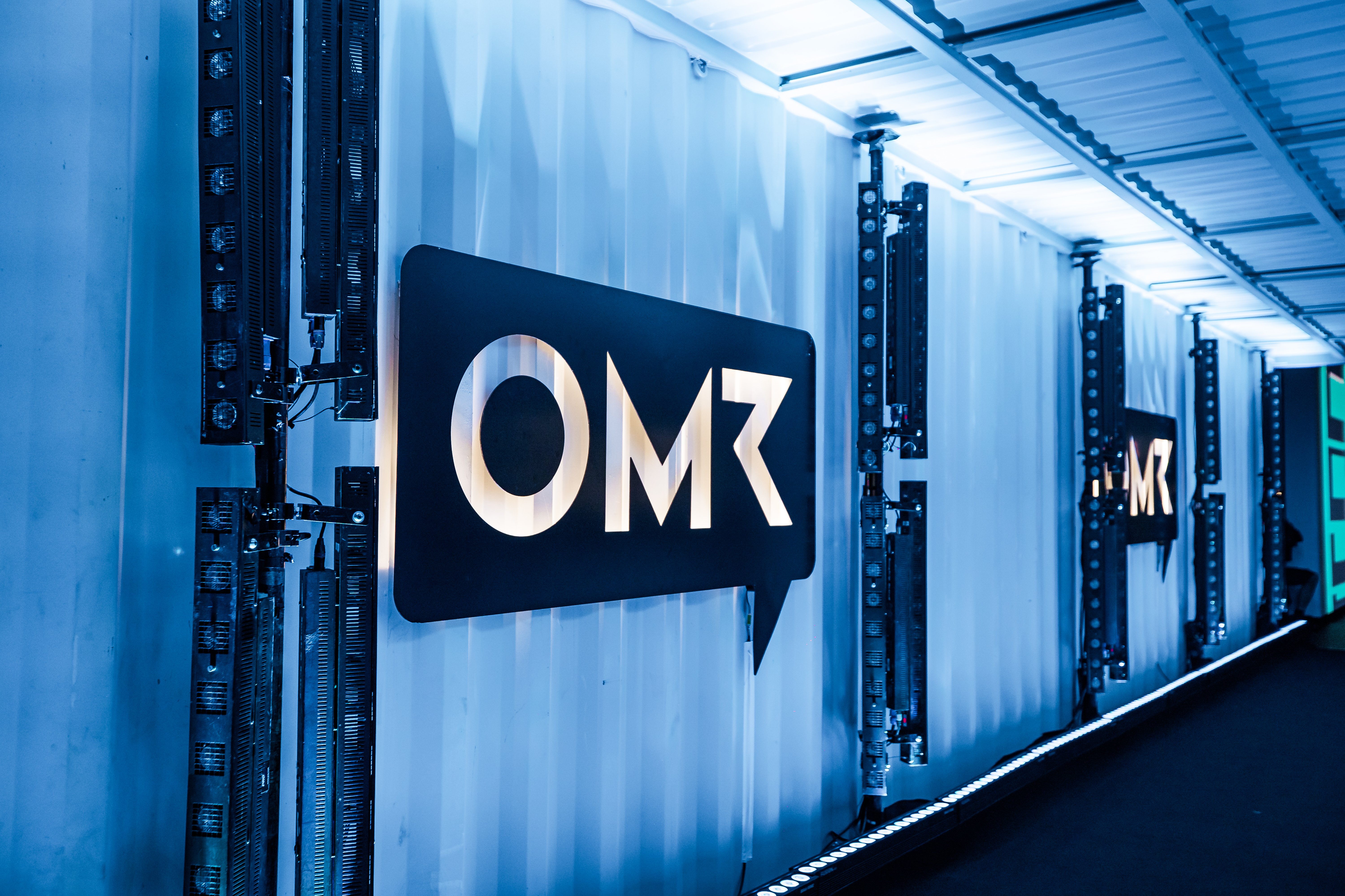 Bild vom OMR Logo in einem langen blau-beleuchteten Gang