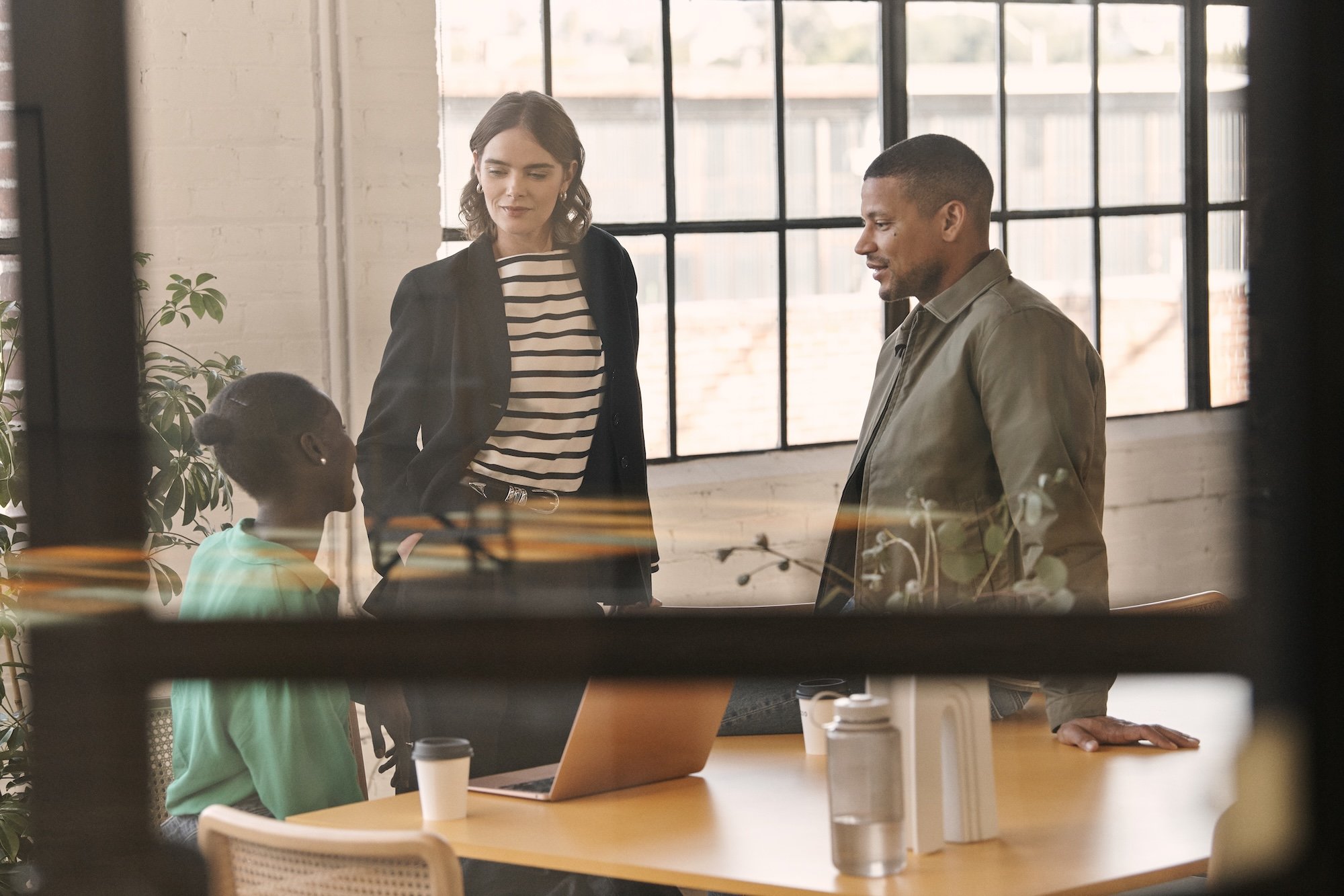 Three professionals speaking to each other in office