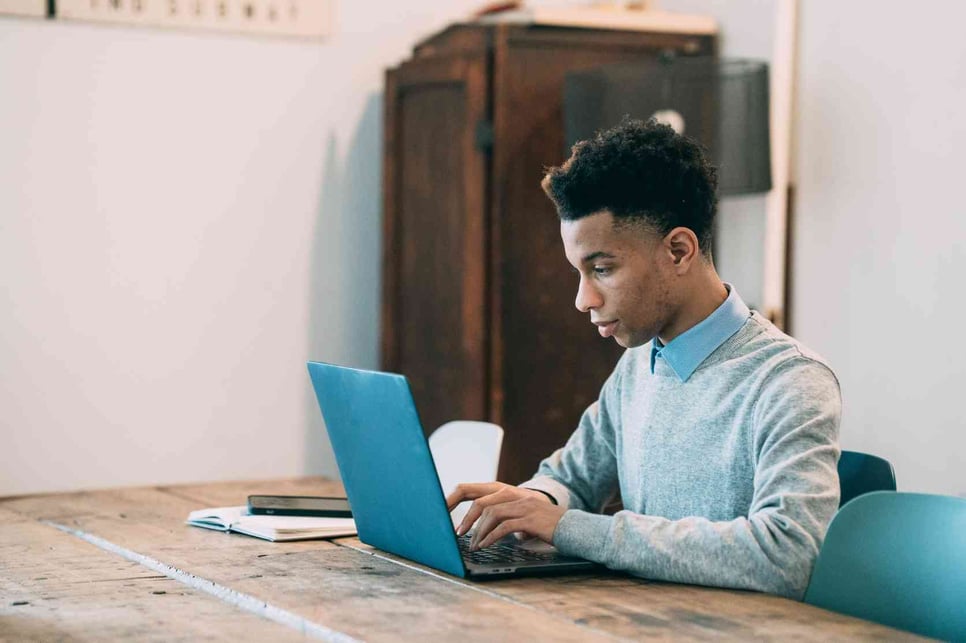 A man sitting in front of his laptop looking for Best Email Signature Quotes for Customization