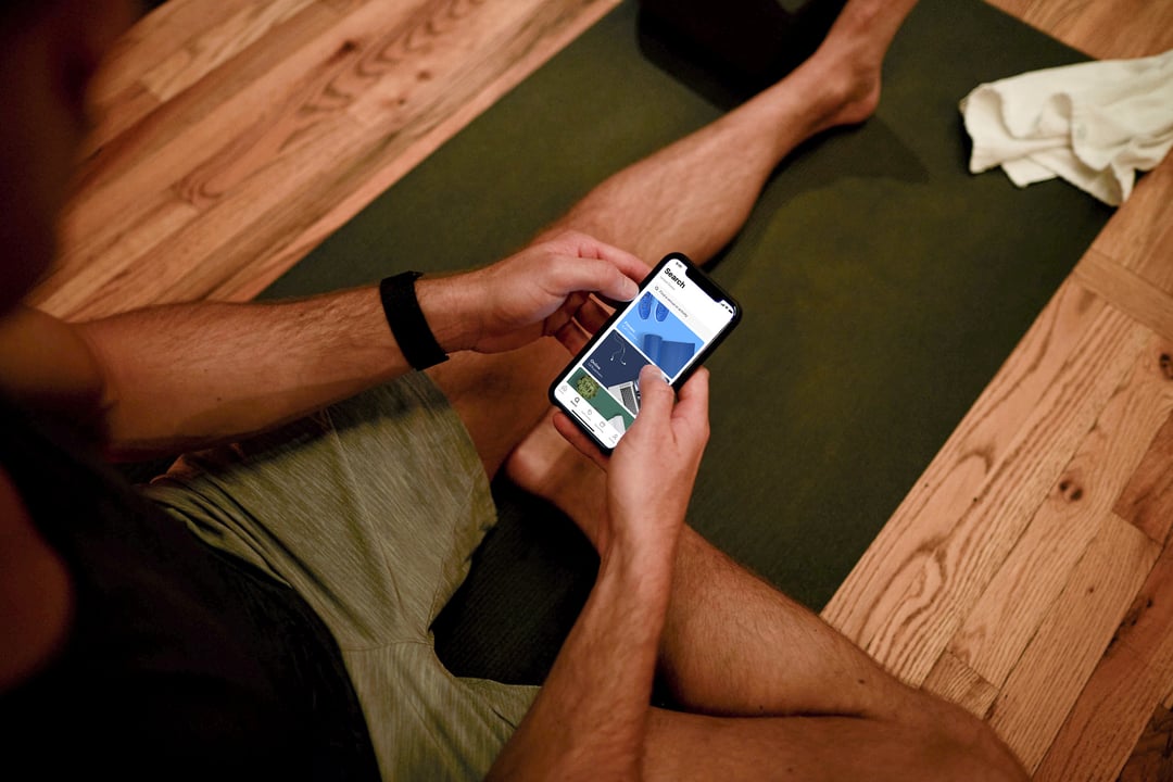 man using classpass app on smartphone