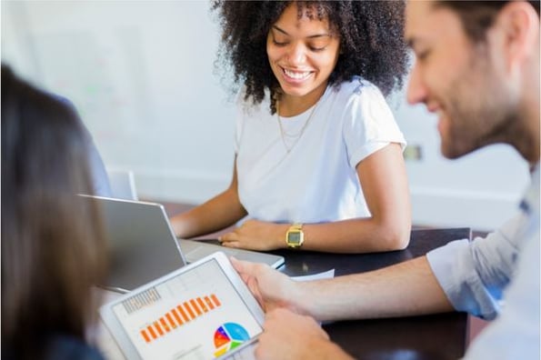 Mitarbeiter sitzen zusammen an einem Tisch und erstellen ein Excel-Diagramm