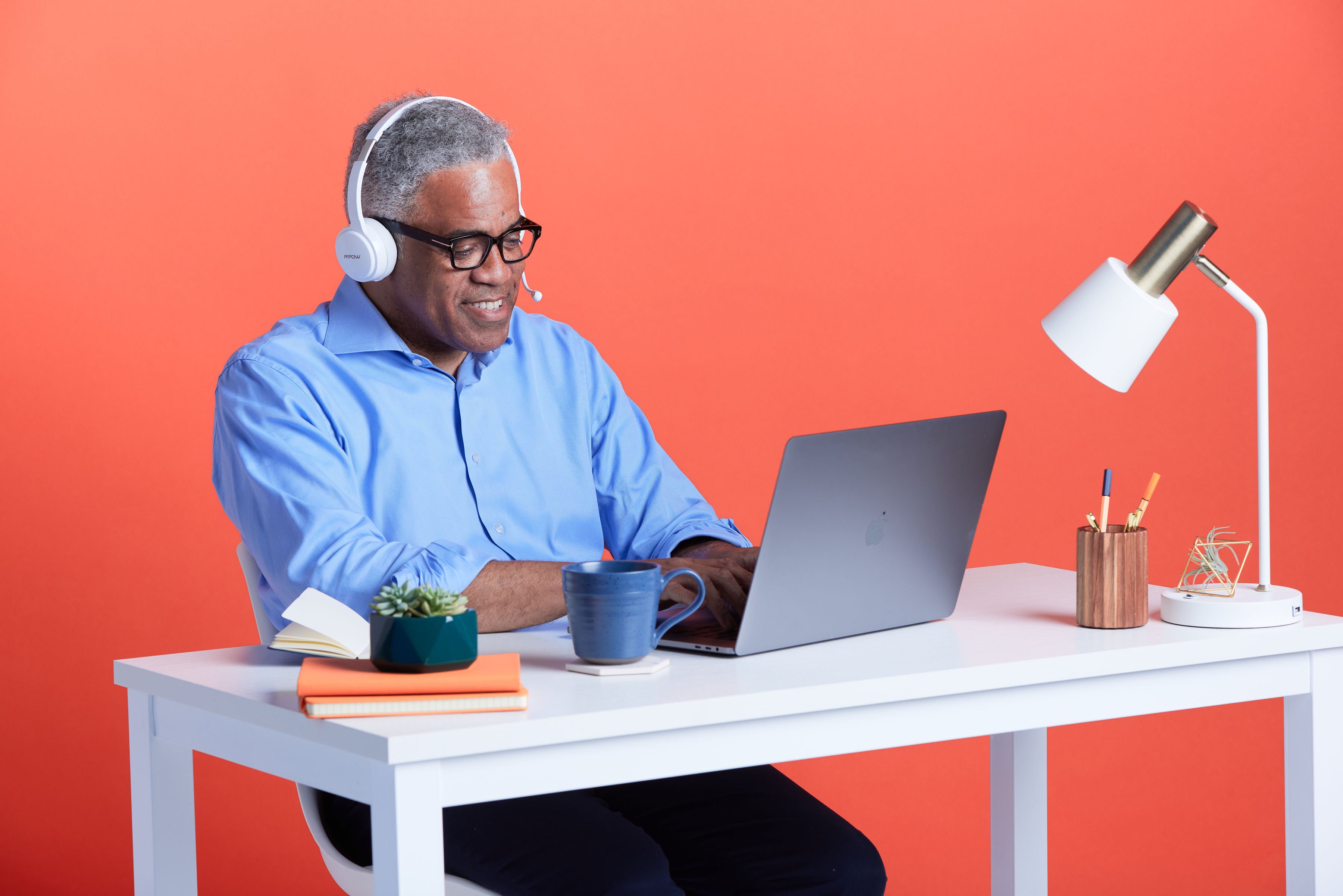 Professional with headset looking at laptop