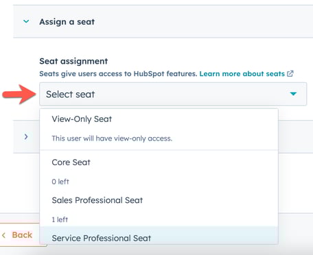 A dropdown menu in HubSpot for assigning a seat to a new user, with various seat types listed.