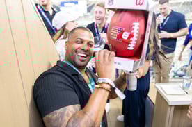 Man holding signed football prize