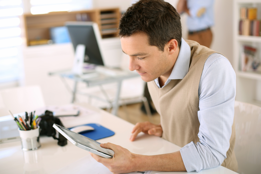 Man on tablet creating an email signature