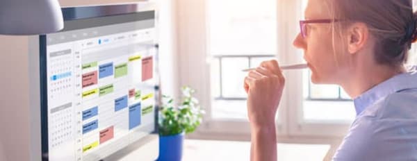 Marketer sits at a computer to organize social media calendar 
