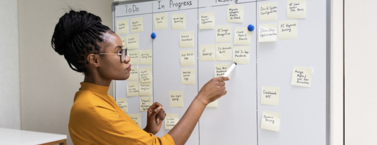 a project manager determines what channels shell use in 2022 with post it notes on a board