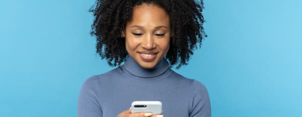 a woman looks at a smartphone with snackable content on it.
