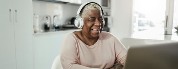 YouTube user sits at home desk with headphones and laughs while watching an ad