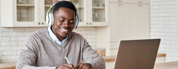 Blogger sits at desk with headphones to draft new post
