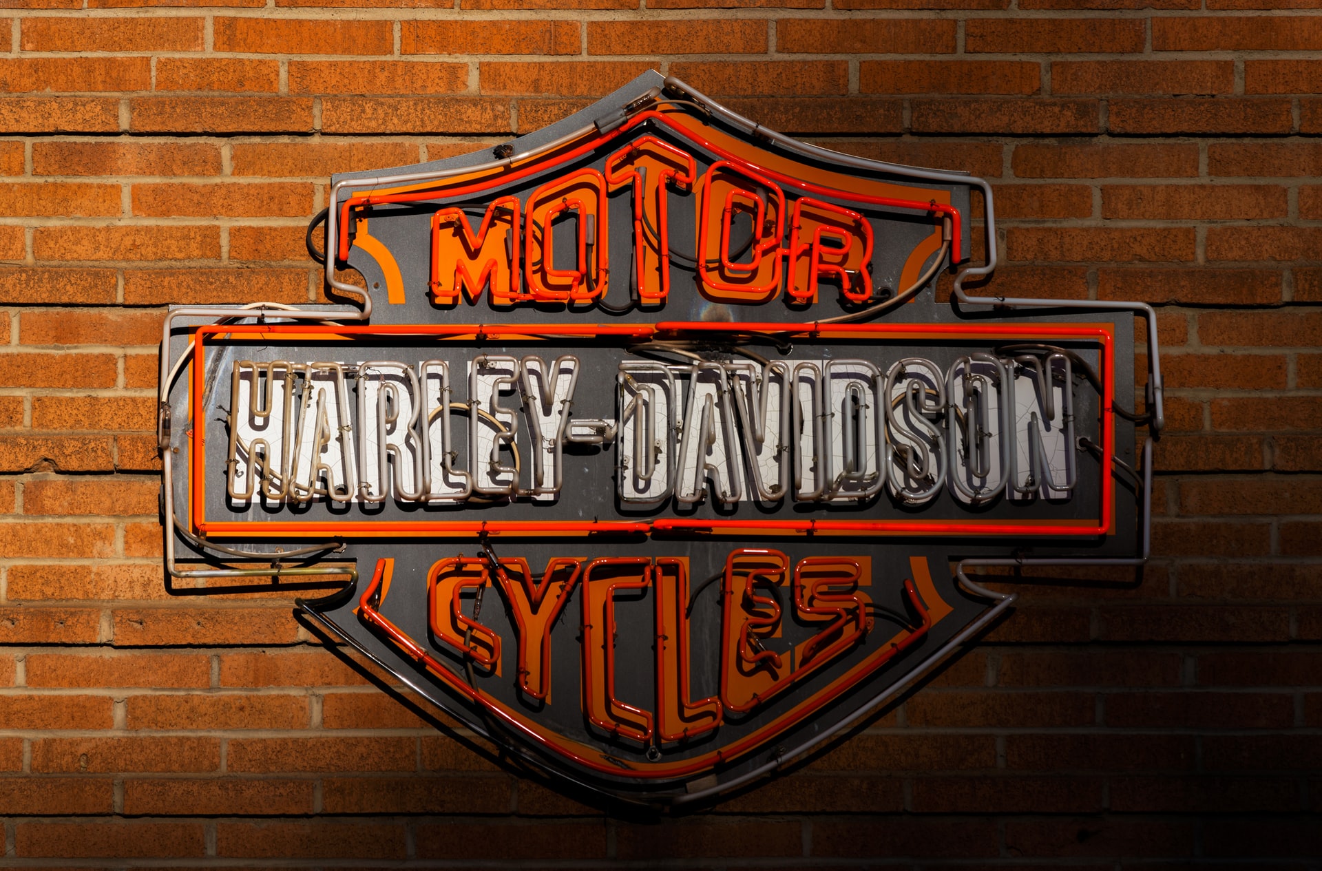 harley-davidson motorcycles neon sign in front of a brick wall