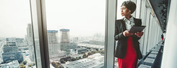 Business leader stands at a window and stares at view of the city