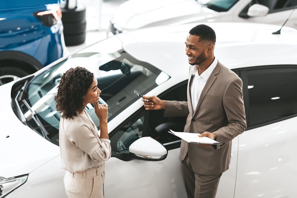 good car salesperson closing a deal with a car shopper