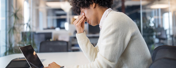 a social media marketer looks stresses at their laptop after a campaign they predicted to do well goes wrong