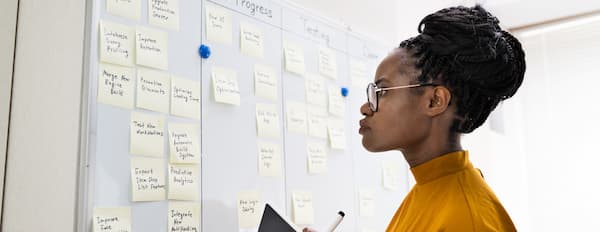 project manager looks at board as she organizes the upcoming project