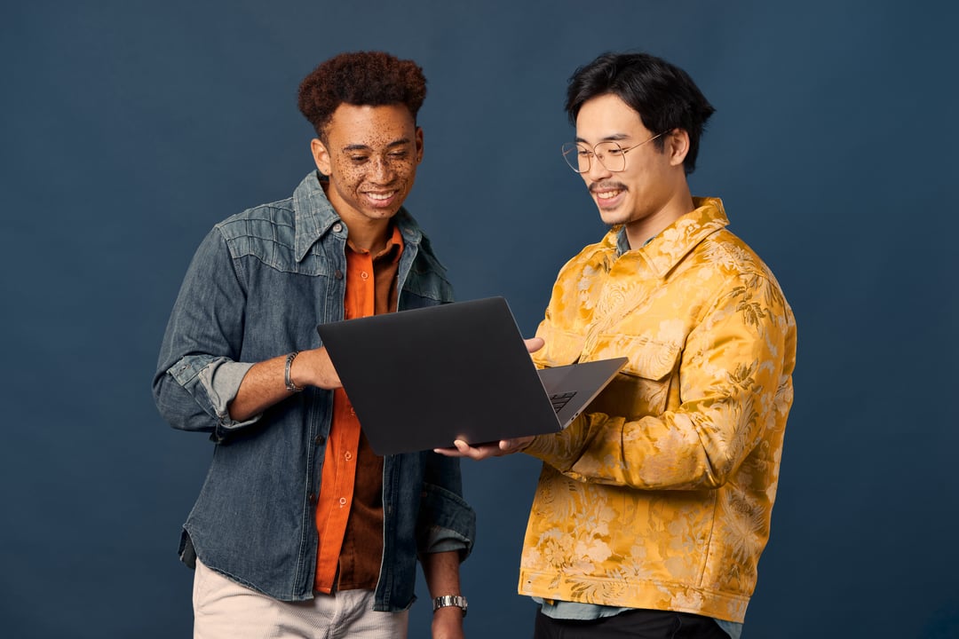 Two professionals smiling looking at laptop