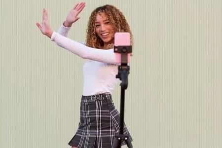 woman posing in front of phone recording tiktok video