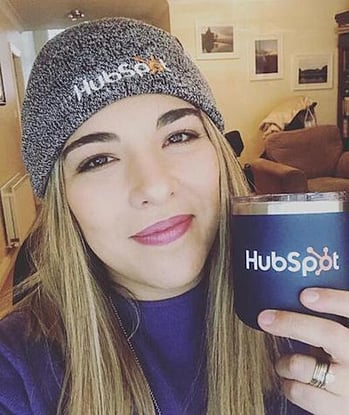 HubSpot employee wearing hat & holding cup