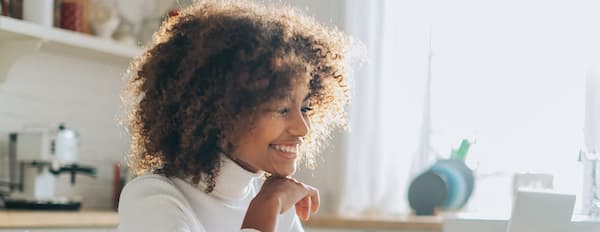 Email marketer sits at desk looking at subscriber list on computer
