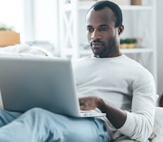 man using a laptop on a couch
