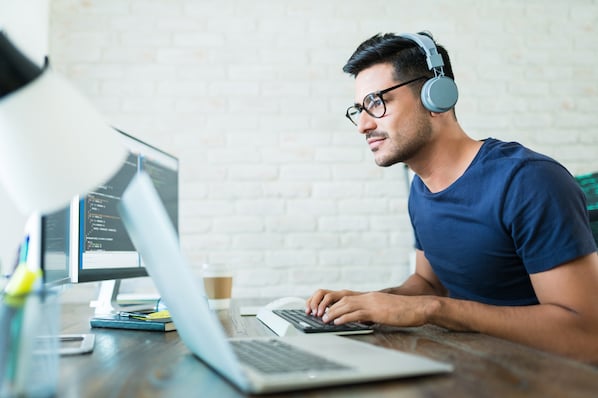 Un homme avec un casque audio travaillant sur un ordinateur