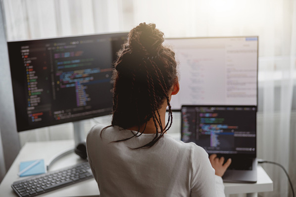 Entwicklerin erstellt Dropdown-Menü in HTML am Computer